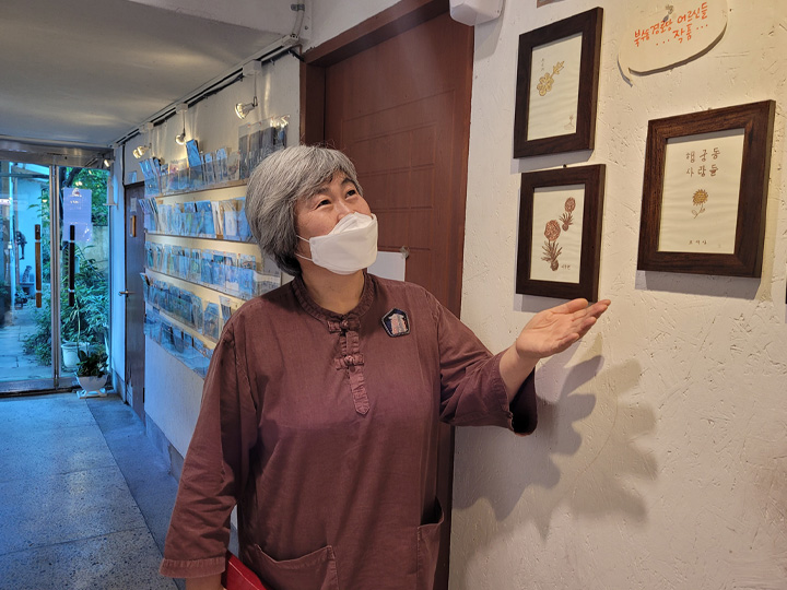 '예술공간 봄'의 이윤숙 대표, 어르신들이 직접 그린 그림이 예쁘다며 액자를 소개했다. 9.1 경기남부뉴스