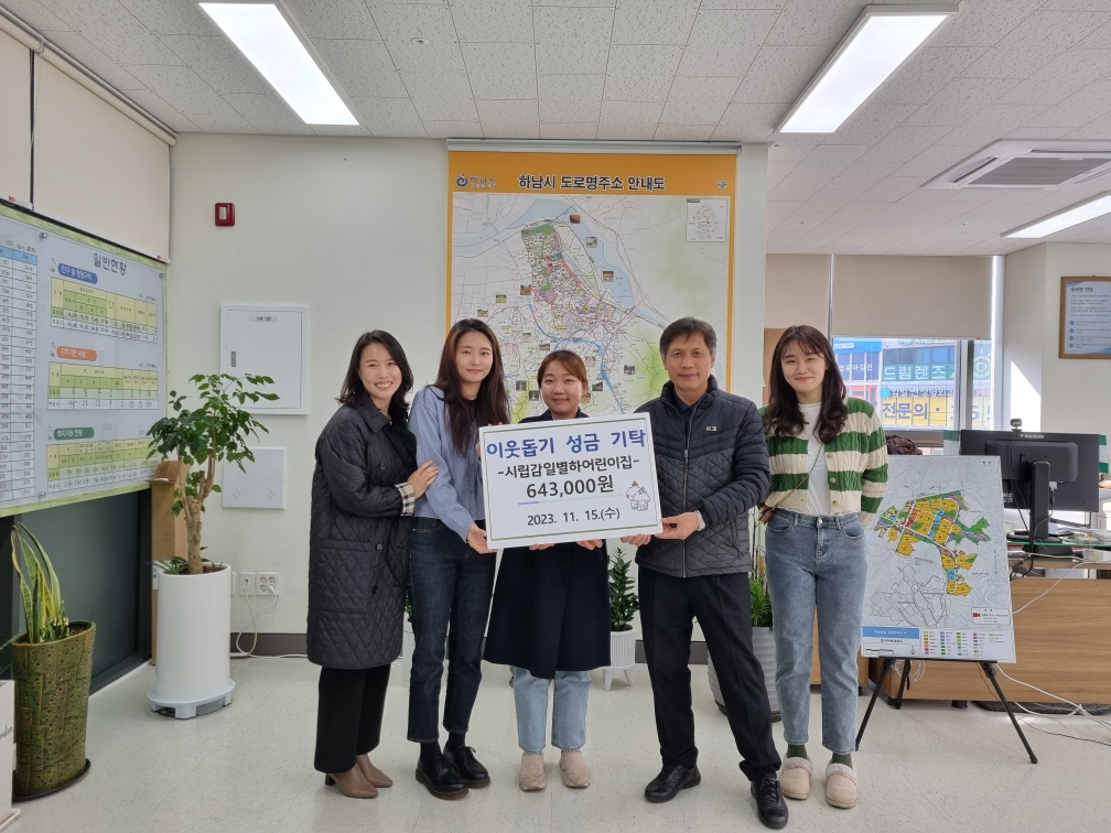 하남시 감일동 시립감일별하어린이집 원장 윤소정과 어린이집 운영위원회 학부모들이 바자회 수익금을 전달하고 있다.