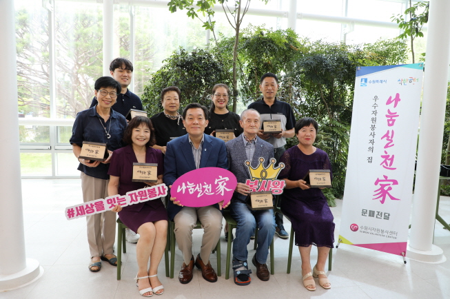 이재준(앞줄 왼쪽에서2번째)수원시장과 우수자원봉사자들이25일 수원시청 새빛민원실에서 문패 전달식을 가진 뒤 기념촬영을 하고 있다.