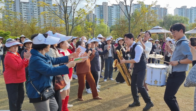 푸라비다(브라스밴드)와 마을만들기 주민들이 일월수목원 야외에서 함께 즐기고 있다.