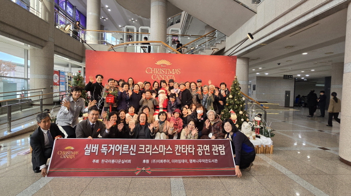 안산문화예술의전당 해돋이극장에서 열린 크리스마스 칸타타 공연에 실버 독거 어르신 40여 명이 관람전 포토존에서 행복한 포즈를 취하며 단체사진을 찍고 있다.