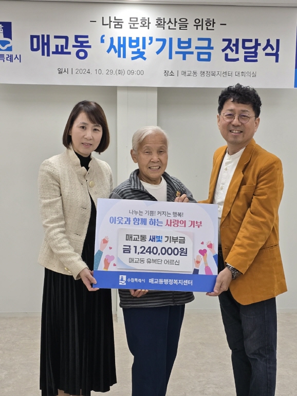 매교동 주민인 유복단 할머니(가운데)가 폐지를 팔아 모은 금액을 새벽빛 장애인학교 이전을 위해 기부하고 있다.