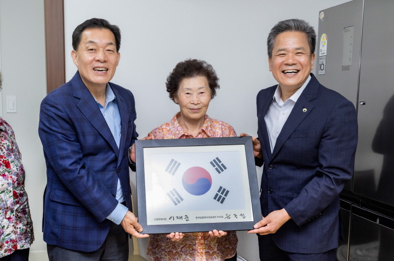 이재준 시장이 강점순씨에게 태극기를 전달하고 있다.